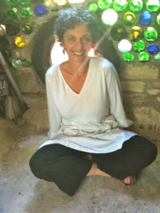 Seja Rachael seated crosslegged before a colorful window